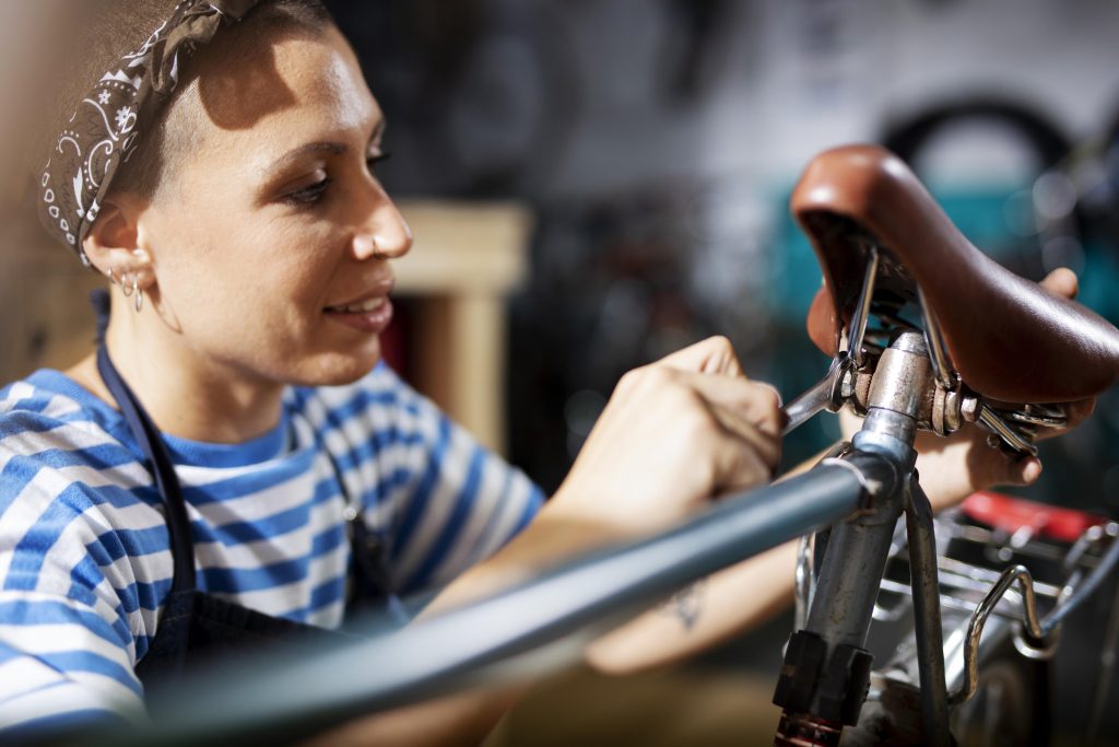 Female freelancer fixing a bicycle