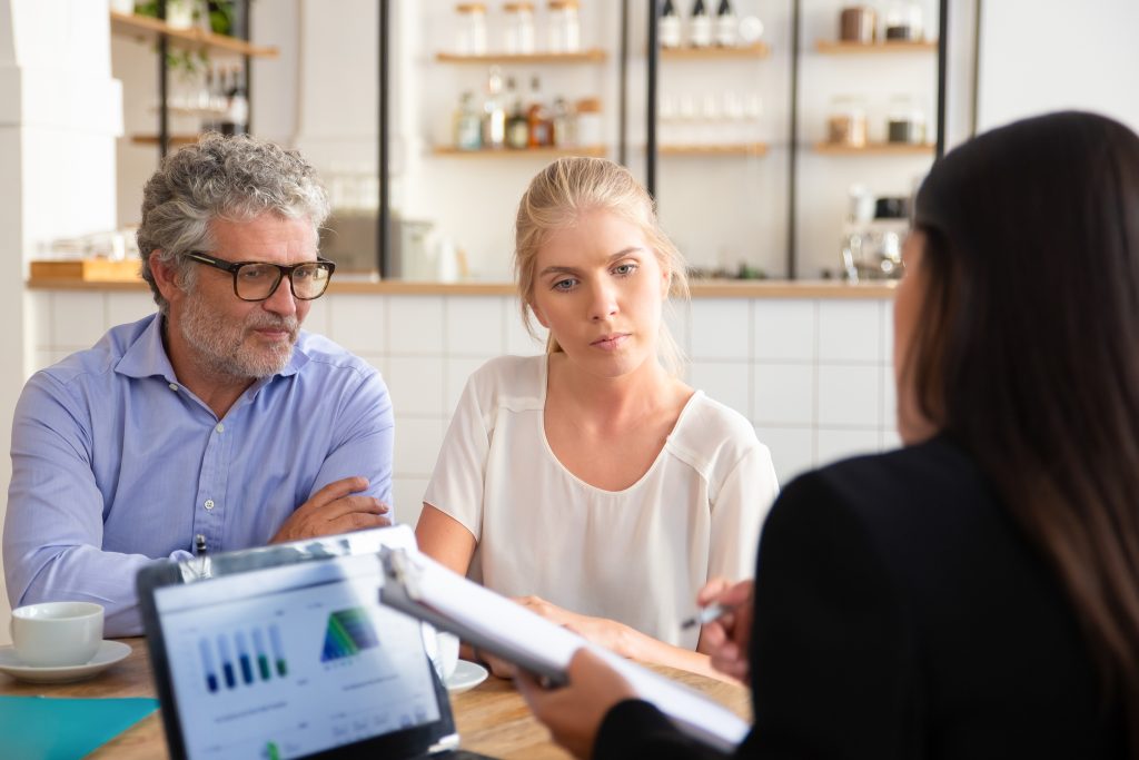 Father and daughter business owners in meeting with female consultant