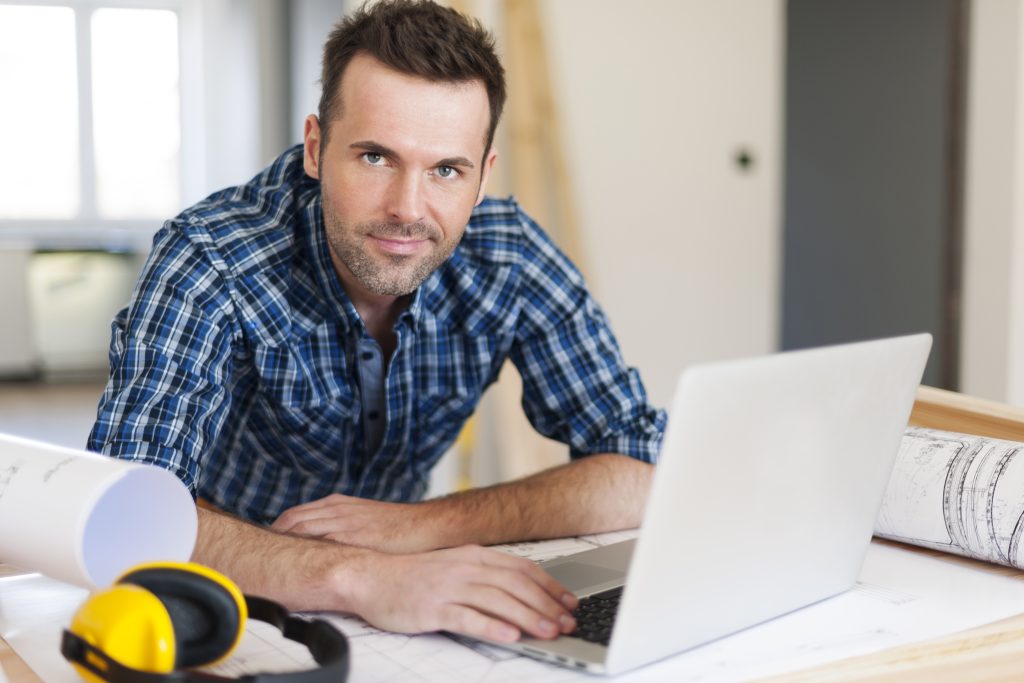 Trades manager working on laptop