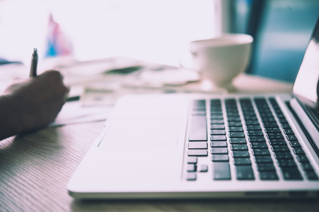 Person sitting working on laptop in dark office
