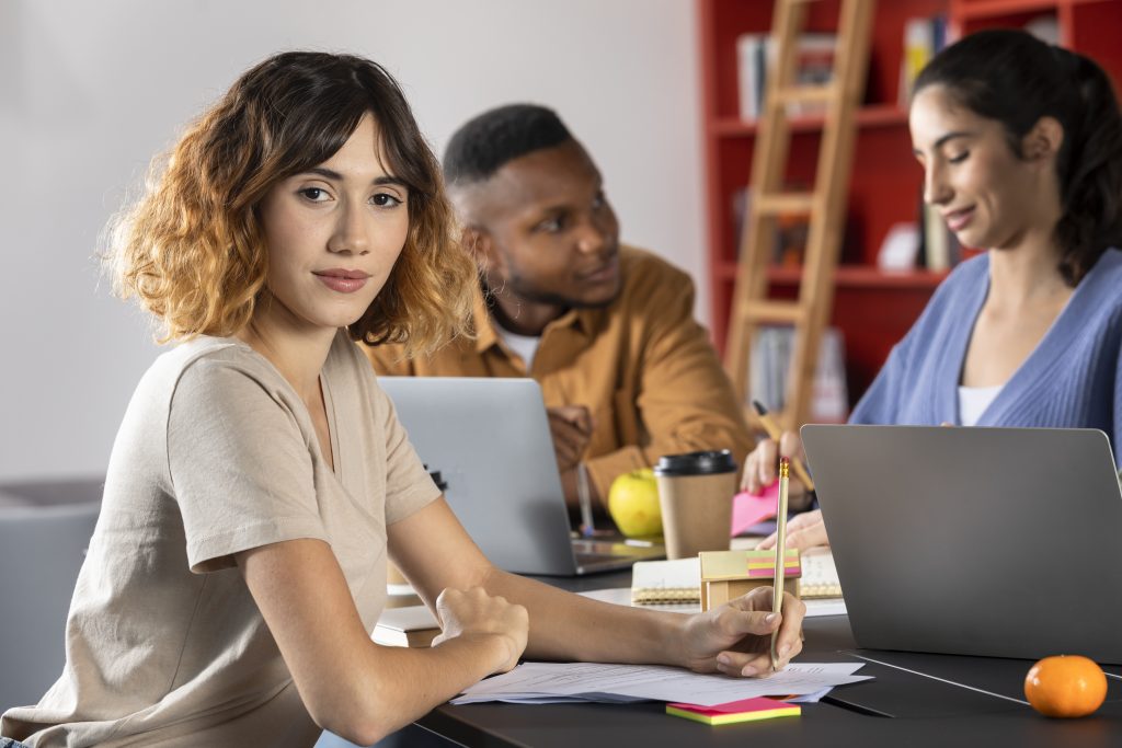 Femail employee looking directly at camera with 2 co workers in background